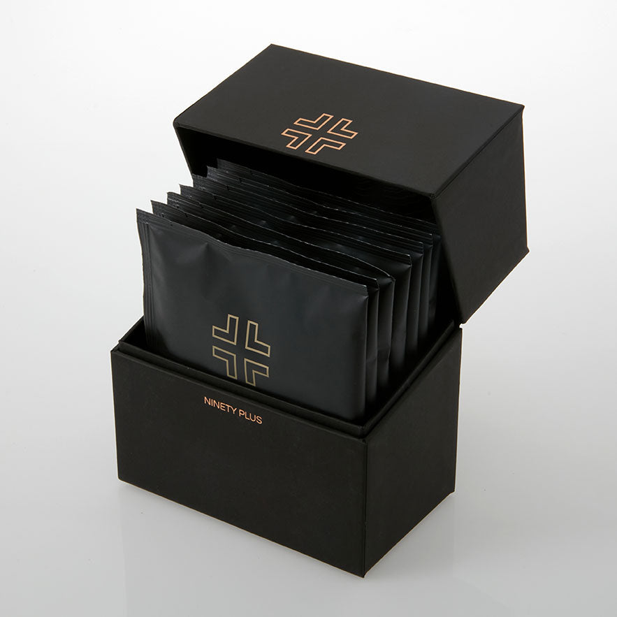 Black packaging box with multiple black packets inside, featuring a logo and brand name.