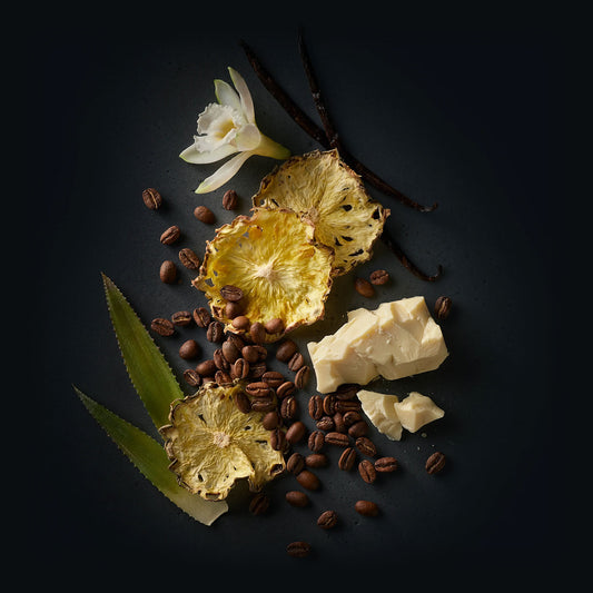 Carmo Coffee by Ninety Plus Coffee. A spread of roasted coffee beans with food items that represent that flavor notes of white chocolate, dried pineapple, and vanilla.
