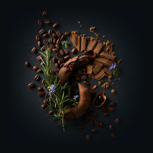 Sillvia Coffee by Ninety Plus Coffee.  A spread of roasted coffee beans with food items that represent that flavor notes of brown sugar, tamarind, and rosemary. 